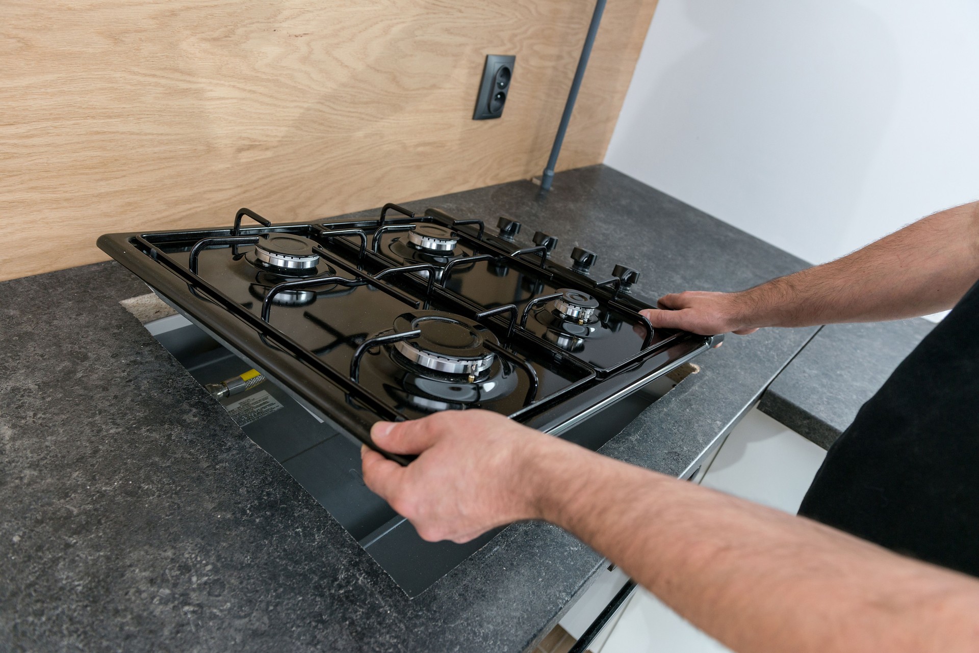 Man installing a gas hob in a kitchen in Bel Air