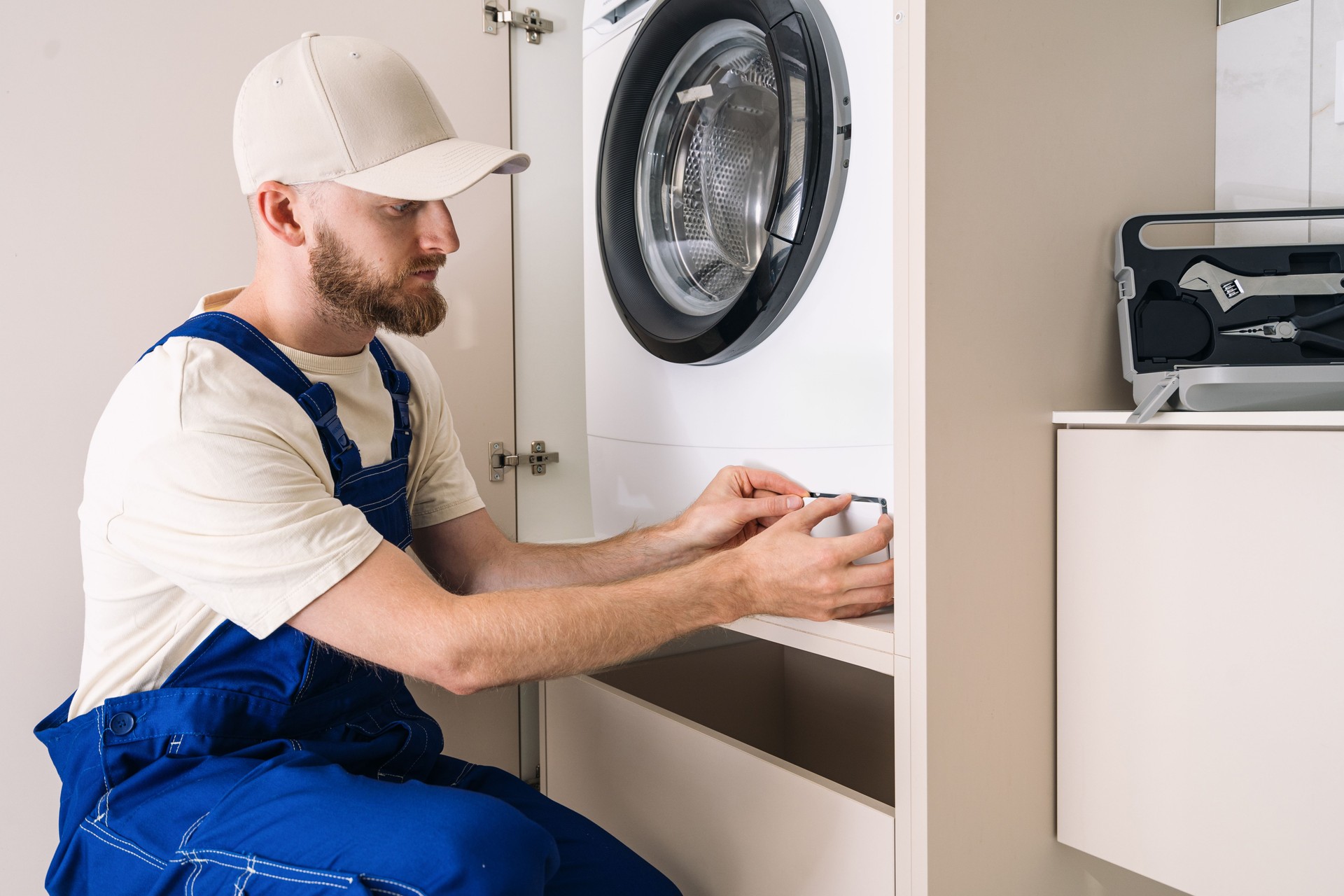 Man installs automatic washing machine in modern laundry room with efficient design in Woodland Hills